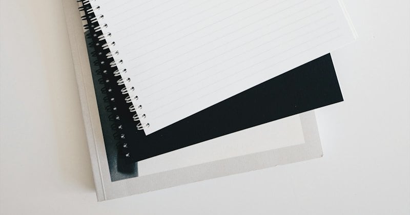 An open notebook and pen beside a keyboard